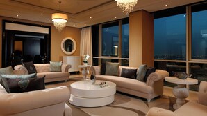 A spacious living room with a large window, a round coffee table, and two sofas. - Millennium Hotel and Convention Centre Kuwait (Salmiya)
