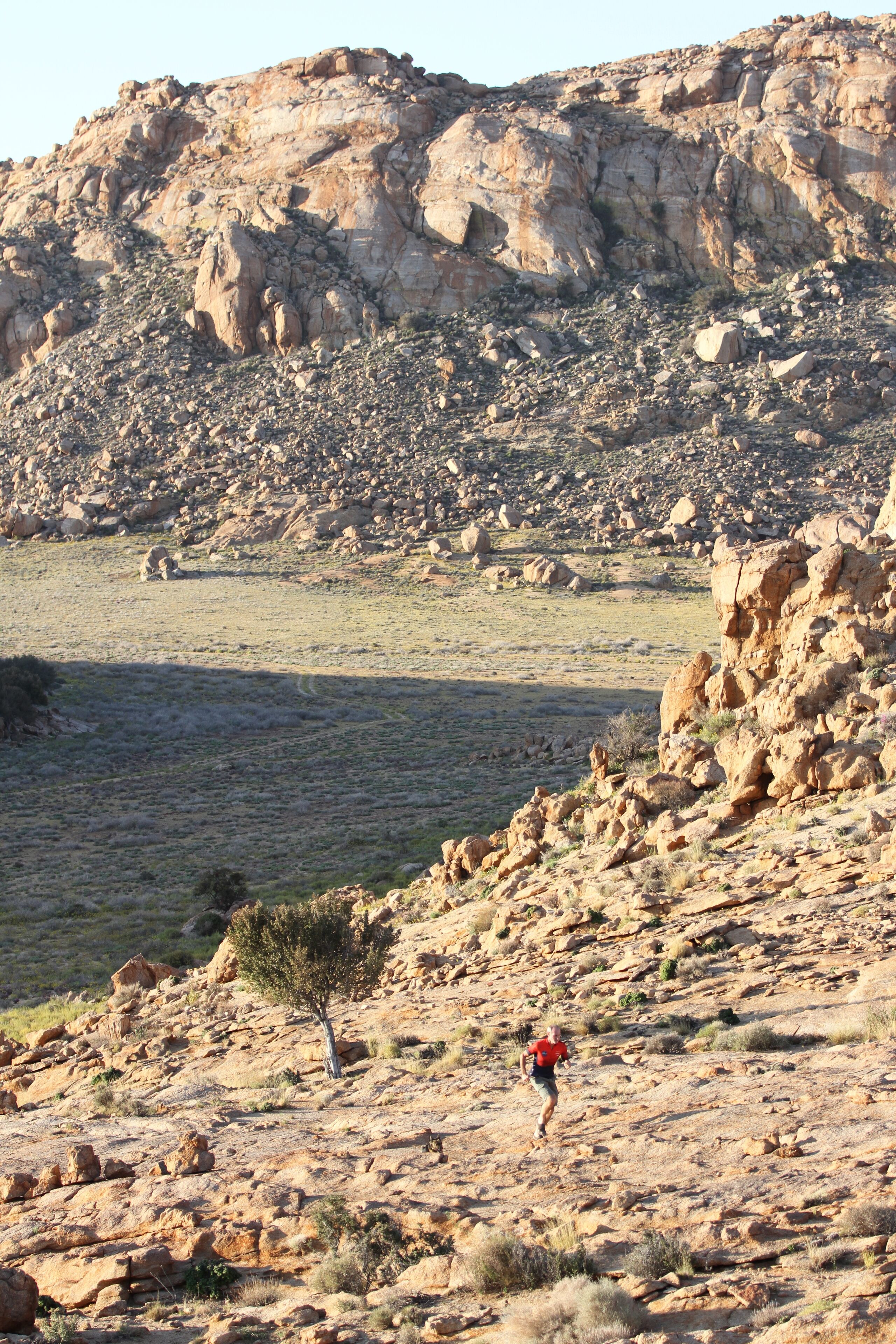 A rocky landscape with a person running.