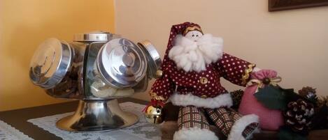 A table with a decorative metal container and a Santa Claus figurine.