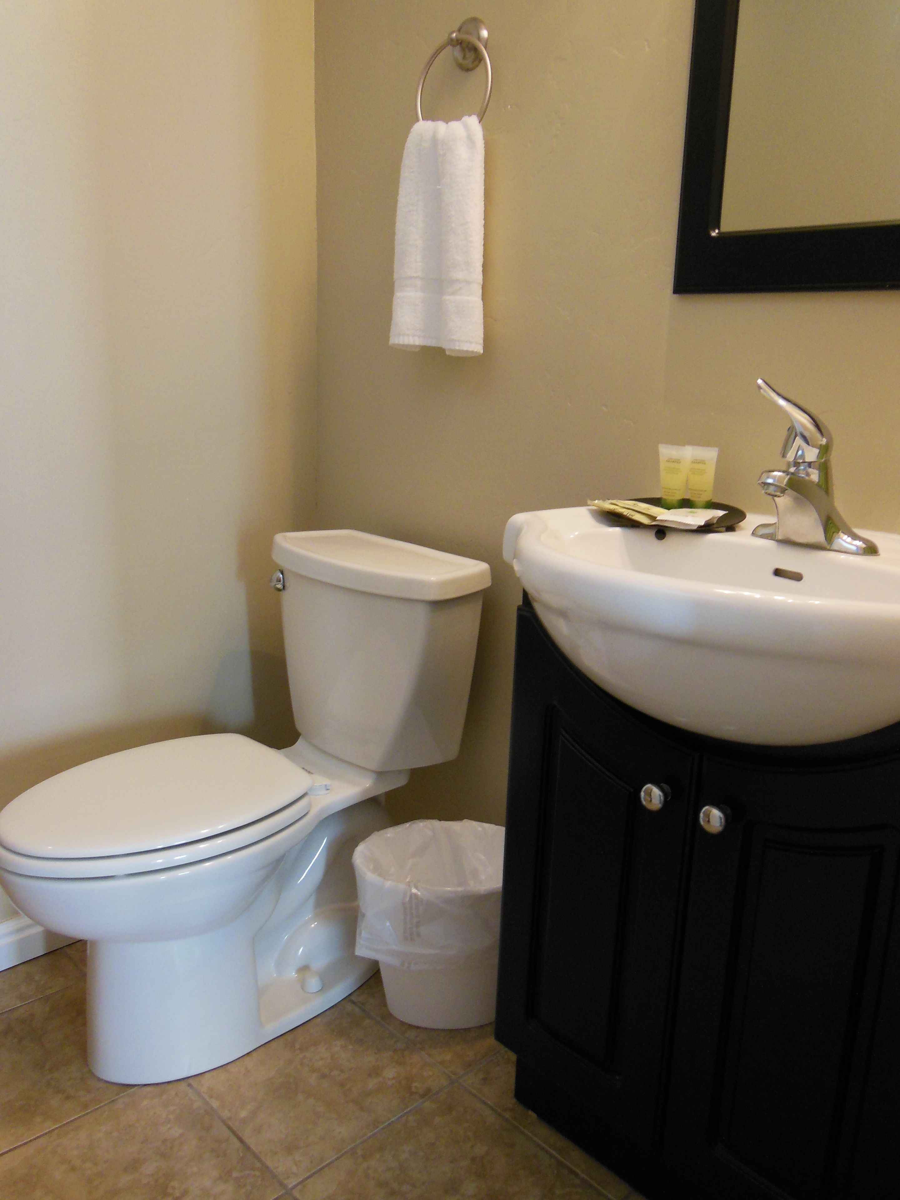 Une salle de bain équipée de toilettes, d’un lavabo et d’une poubelle.