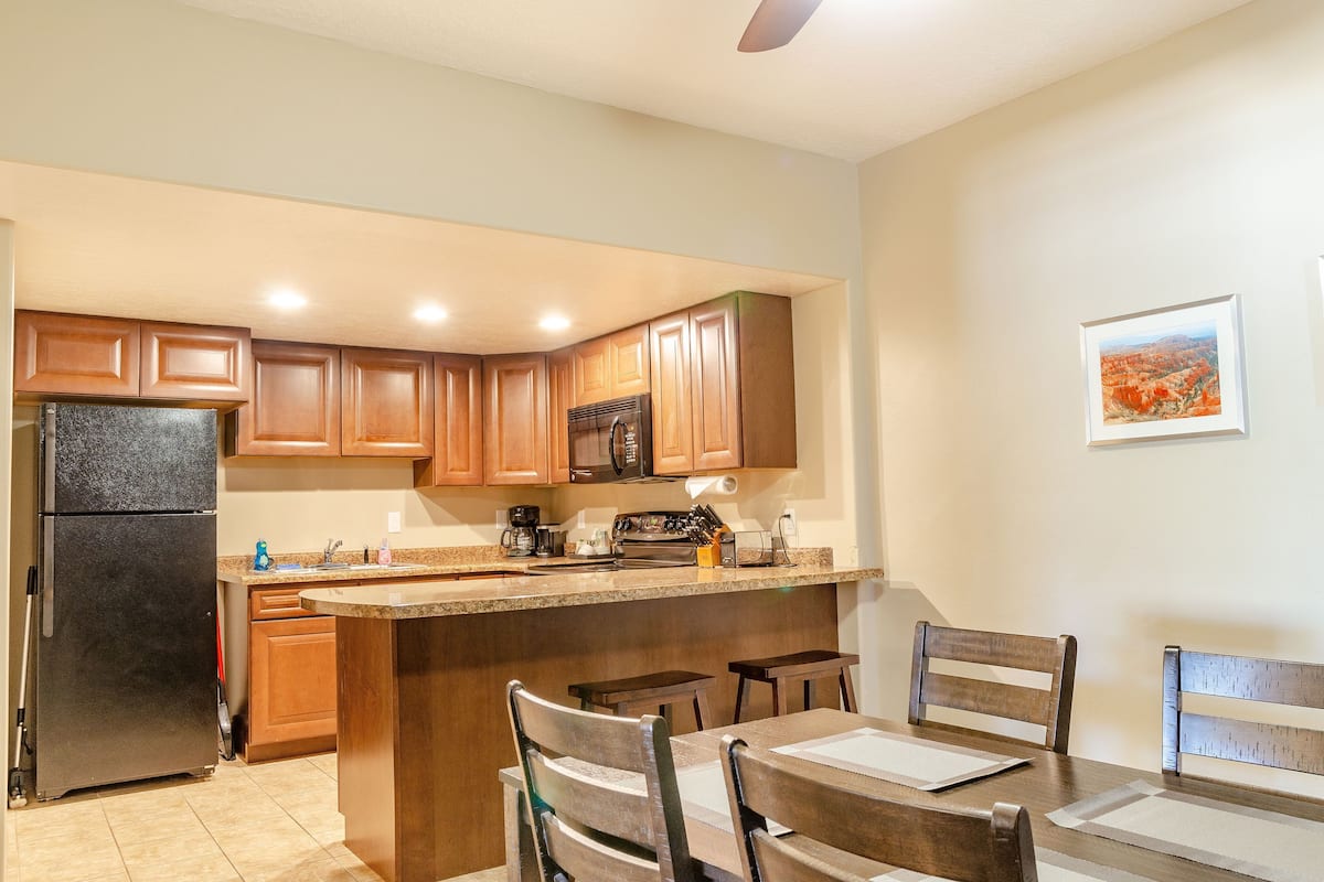 A kitchen with wooden cabinets, a refrigerator, a microwave, and a coffee maker.