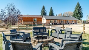 A rustic lodge with outdoor seating and a fire pit. - Mountain Ridge Cabins and Lodging (Hatch)