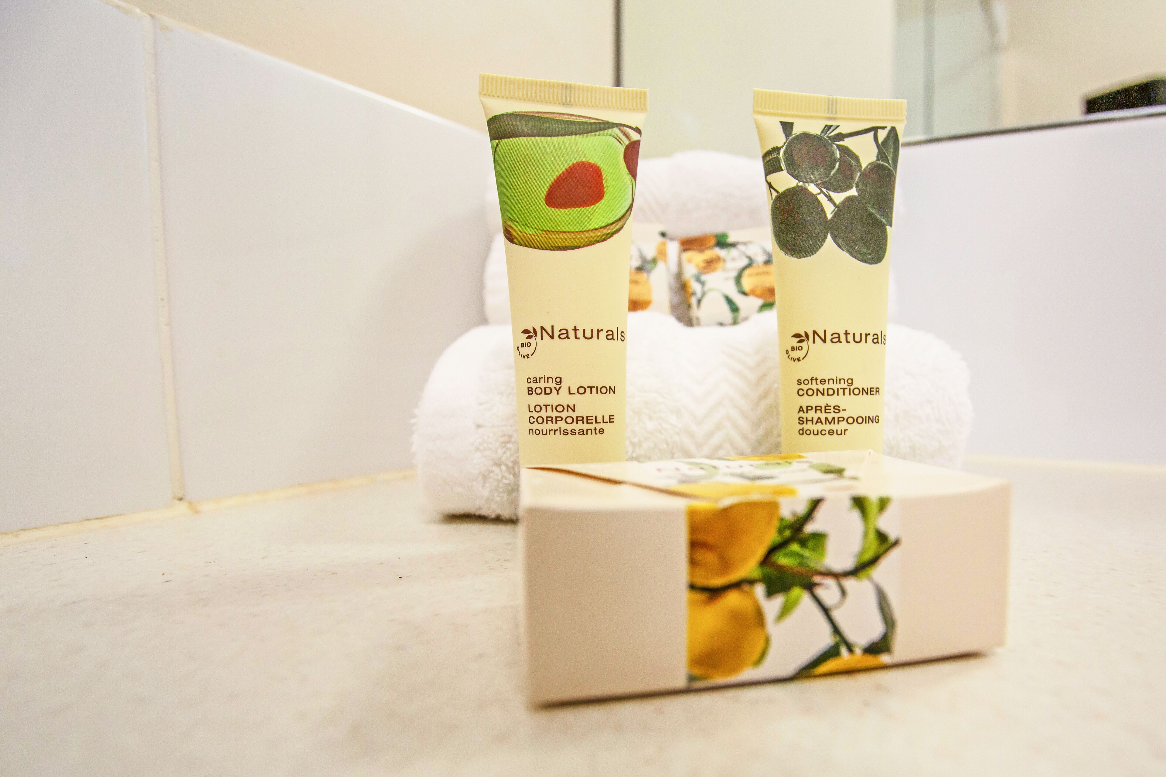 Deux tubes de lotion et d’après-shampoing pour le corps de la gamme Naturals, et une boîte décorée de roses jaunes.