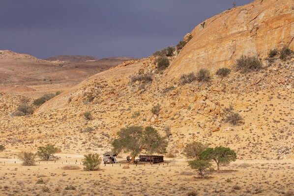 A desert landscape with rocky terrain and sparse vegetation. - Klein-Aus Vista Desert Horse Campsite (Aus)