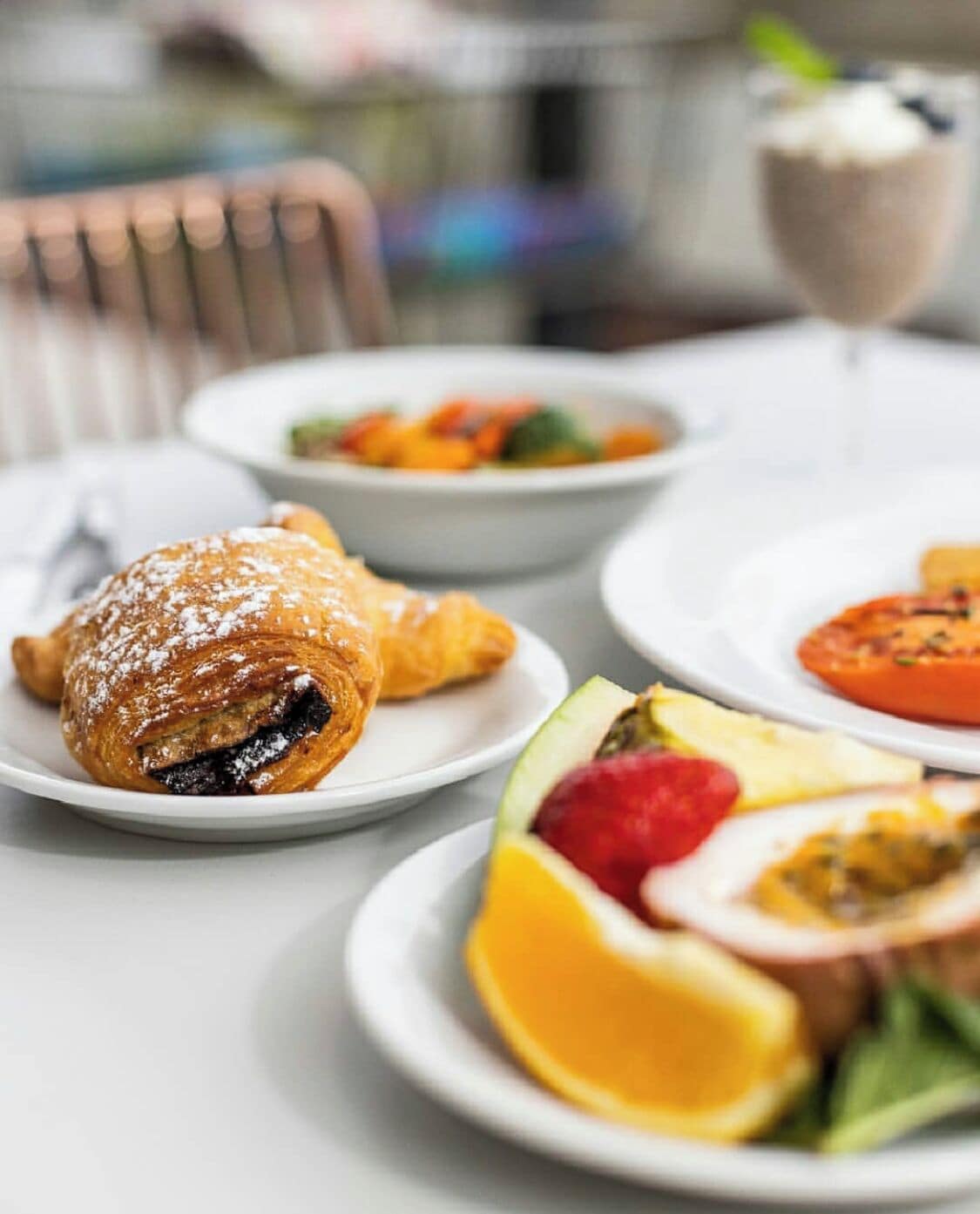 A table with food items including a pastry, fruit, and a dessert.
