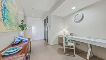 A modern room with a desk, chair, and a clock on the wall.