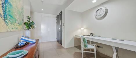 A modern room with a desk, chair, and a clock on the wall.