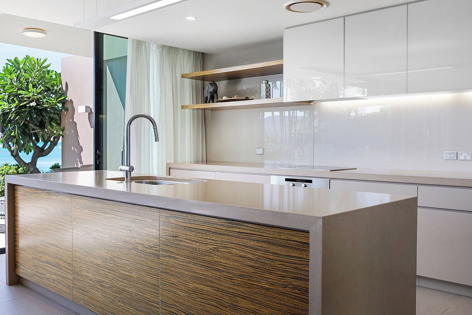 Una cocina moderna con una isla central, electrodomésticos de acero inoxidable y un diseño minimalista.