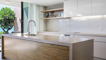 Una cocina moderna con una isla central, electrodomésticos de acero inoxidable y un diseño minimalista.