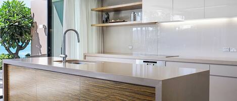 A modern kitchen with a central island, stainless steel appliances, and a minimalist design.