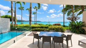 An outdoor dining area with a view of the sea and boats. - Mirage Whitsundays (Cannonvale)