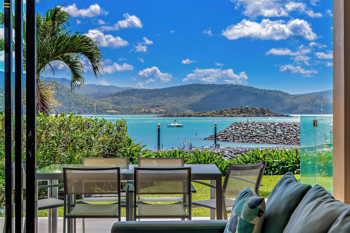 Un espace repas avec vue sur une plage et des montagnes.