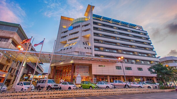Um hotel de vários andares com design moderno, apresentando uma fachada curva marcante e diversas varandas.