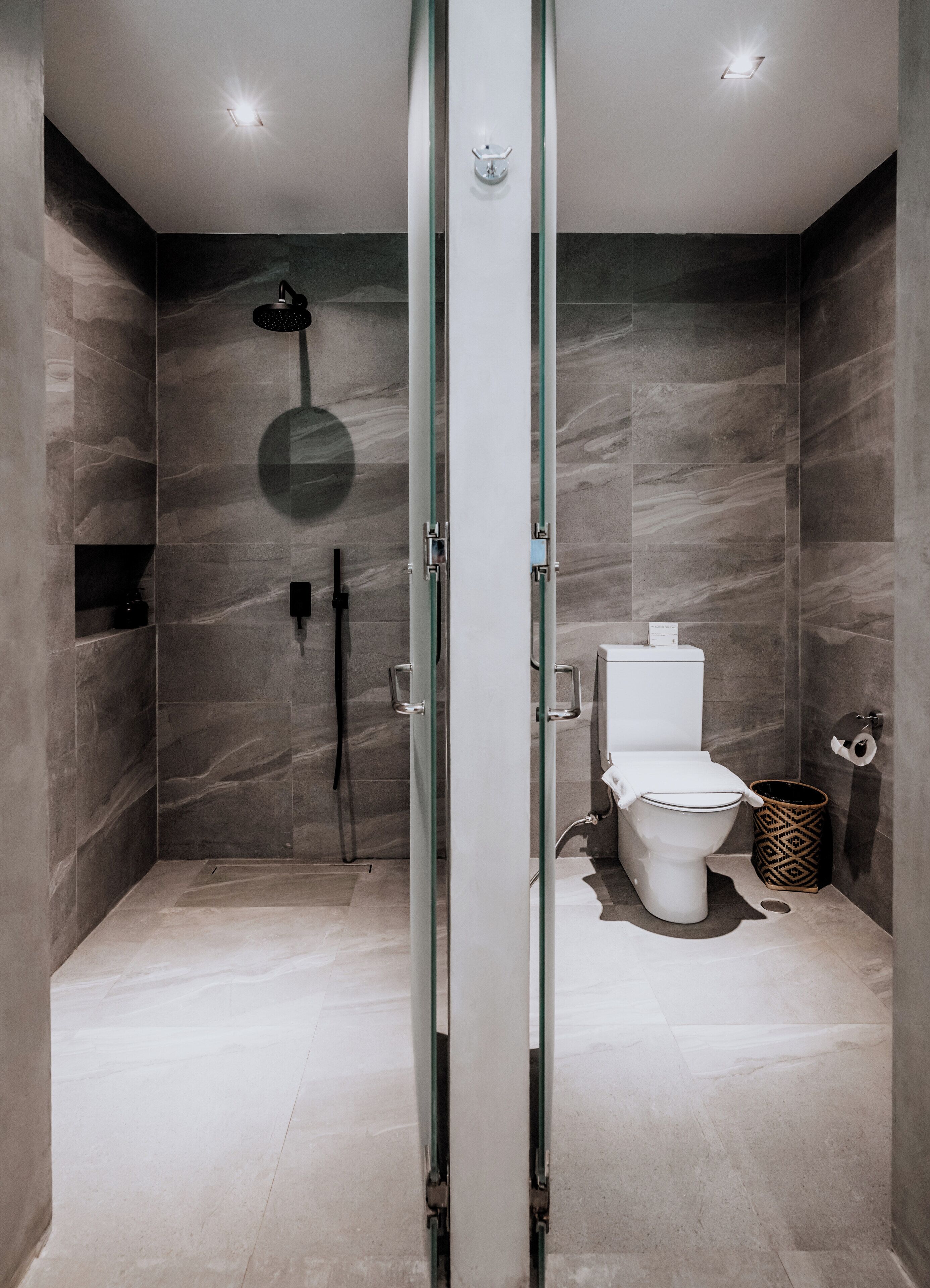 Un baño moderno con cabina de ducha de vidrio, inodoro y bidé.