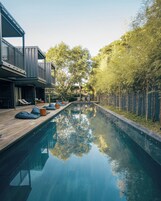 Una piscina al aire libre, sillones reclinables de piscina