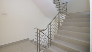 A staircase with metal railings and a handrail, leading to an upper floor. - My Residence Cirebon (West Cirebon)