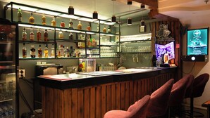 A bar area with shelves of bottles, glasses, and a neon sign. - Jullundur Hotel (Chandigarh)