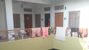 Un edificio residencial de varios niveles con balcones, unidades de aire acondicionado y un patio central.