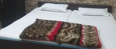 A bed with a patterned blanket, white pillows, and a dark headboard.