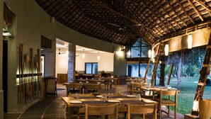 Een restaurant met een gebogen plafond en houten tafels en stoelen.