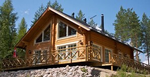 A wooden cabin with large windows, a balcony, and a chimney. - Jämsän Gasthaus (Jamsa)