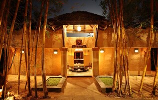 Una entrada bien iluminada a un spa, con un letrero que dice "Visramam Ayur Health Spa".