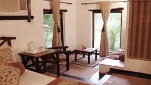 A room with a bed, a table, and a window with curtains. - Tuli Tiger Resort (Bichhiya)