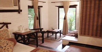 Una habitación con cama, una mesa y una ventana con cortinas.