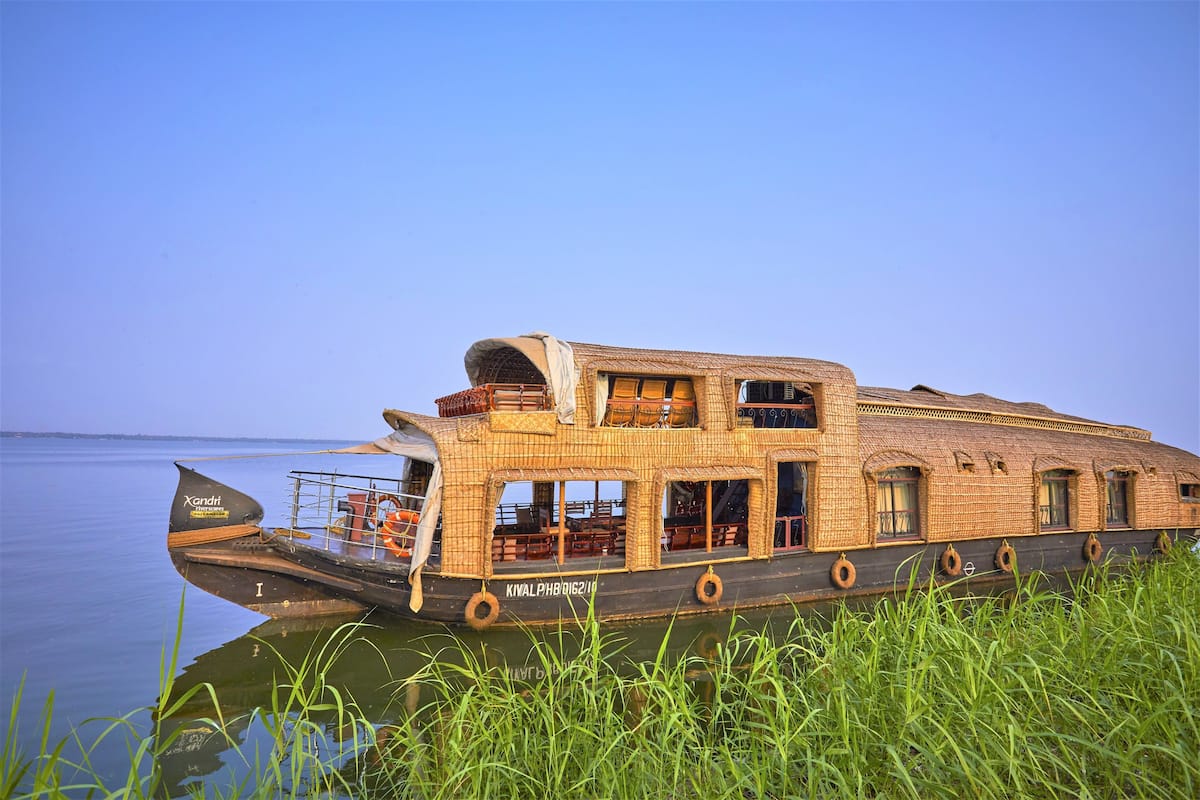 Una casa flotante con techo plano, varias ventanas y un área de comedor visible.