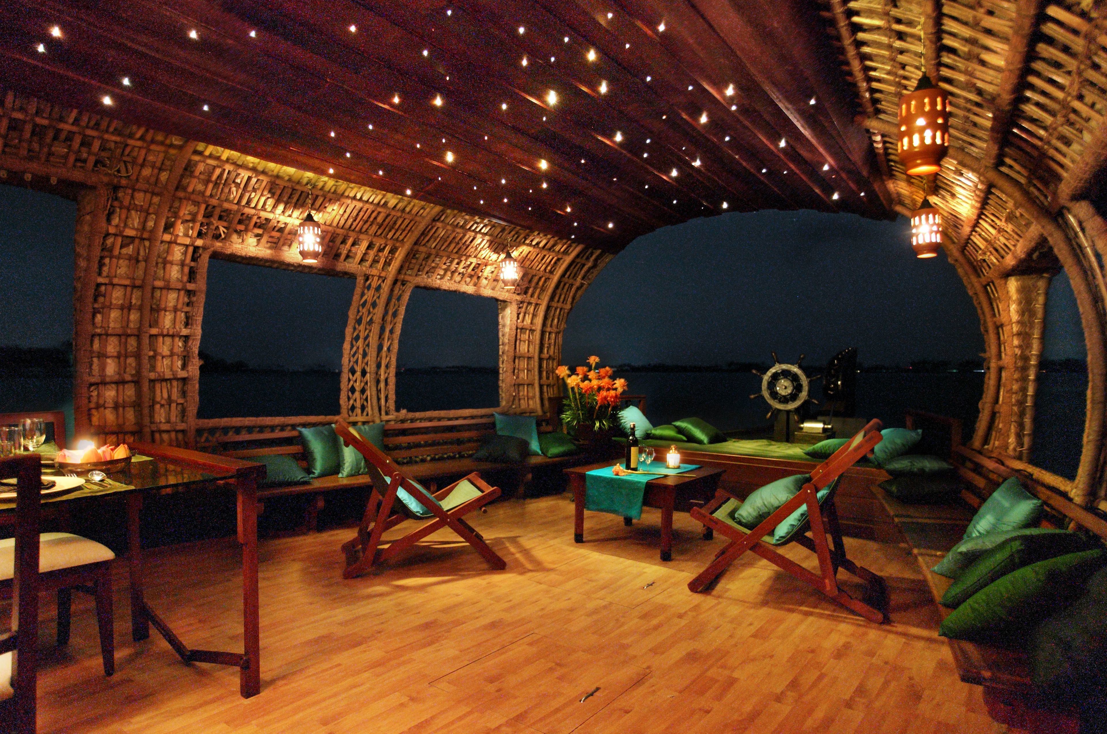 A dining area with wooden furniture and a view of the sea.