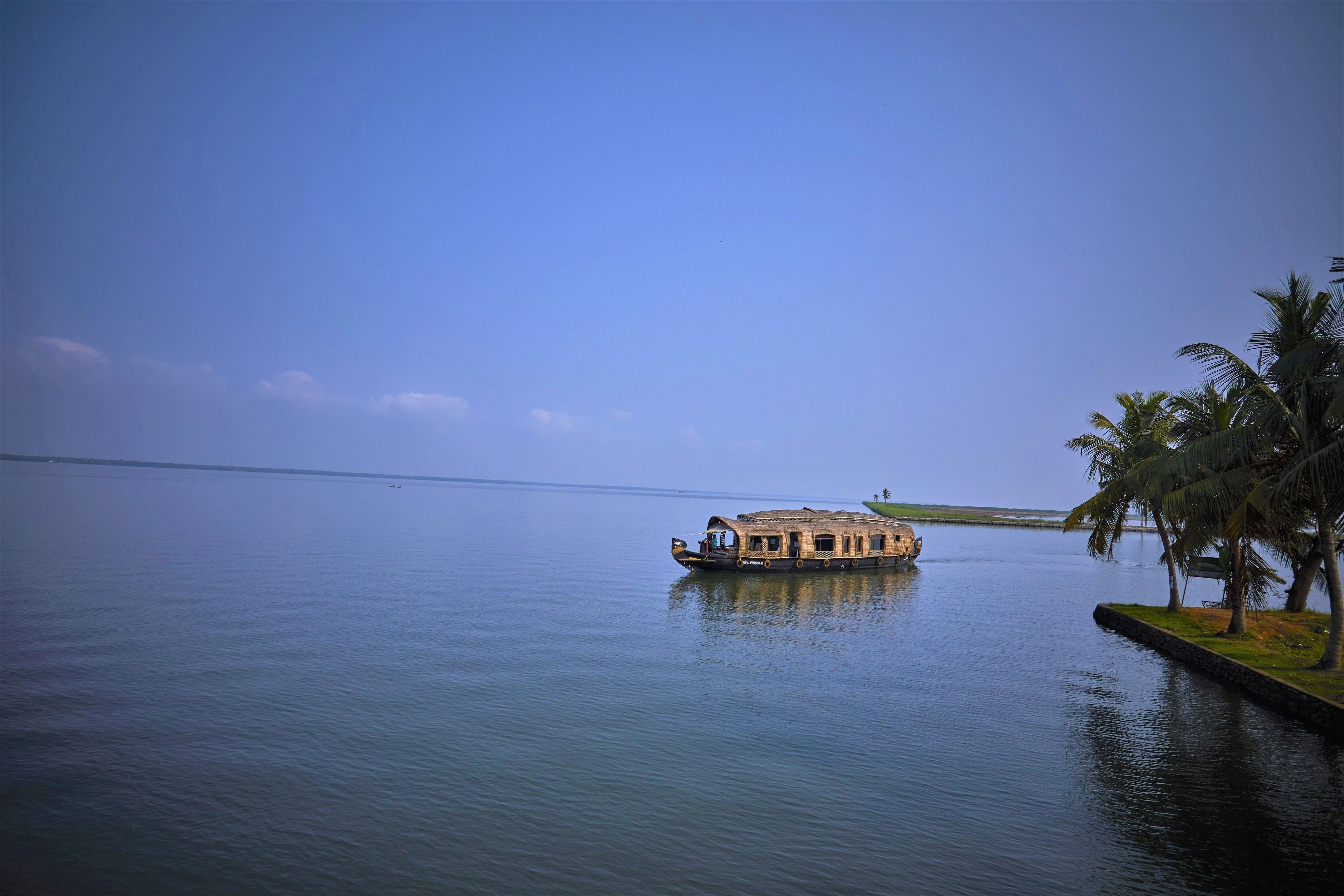 A houseboat on calm water with a clear sky.