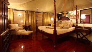 A four-poster bed with a wooden frame, a matching nightstand, a bedside table, and a chair with a cushion. - Tuli Tiger Corridor (Kurai)