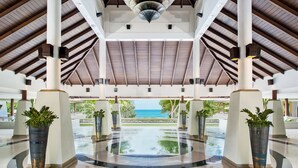 Un vaste atrium doté d’un haut plafond, de grandes colonnes et d’un élément décoratif central composé d’un bassin d’eau réfléchissant.