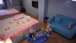 A bedroom with two beds, a blue sofa, and a play area with toys. - Childfun B&B Tong Wan (Luodong)