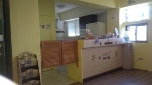 A kitchen with a wooden counter, a water dispenser, and a window with blinds. - Childfun B&B Tong Wan (Luodong)