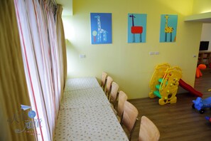 A room with a long table, chairs, and children's toys. - Childfun B&B Tong Wan (Luodong)