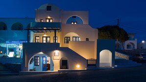 Un edificio de varios pisos con un estilo arquitectónico moderno, que presenta arcos y balcones.