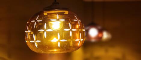 A close-up of a spherical pendant light with a patterned design, hanging from a ceiling.