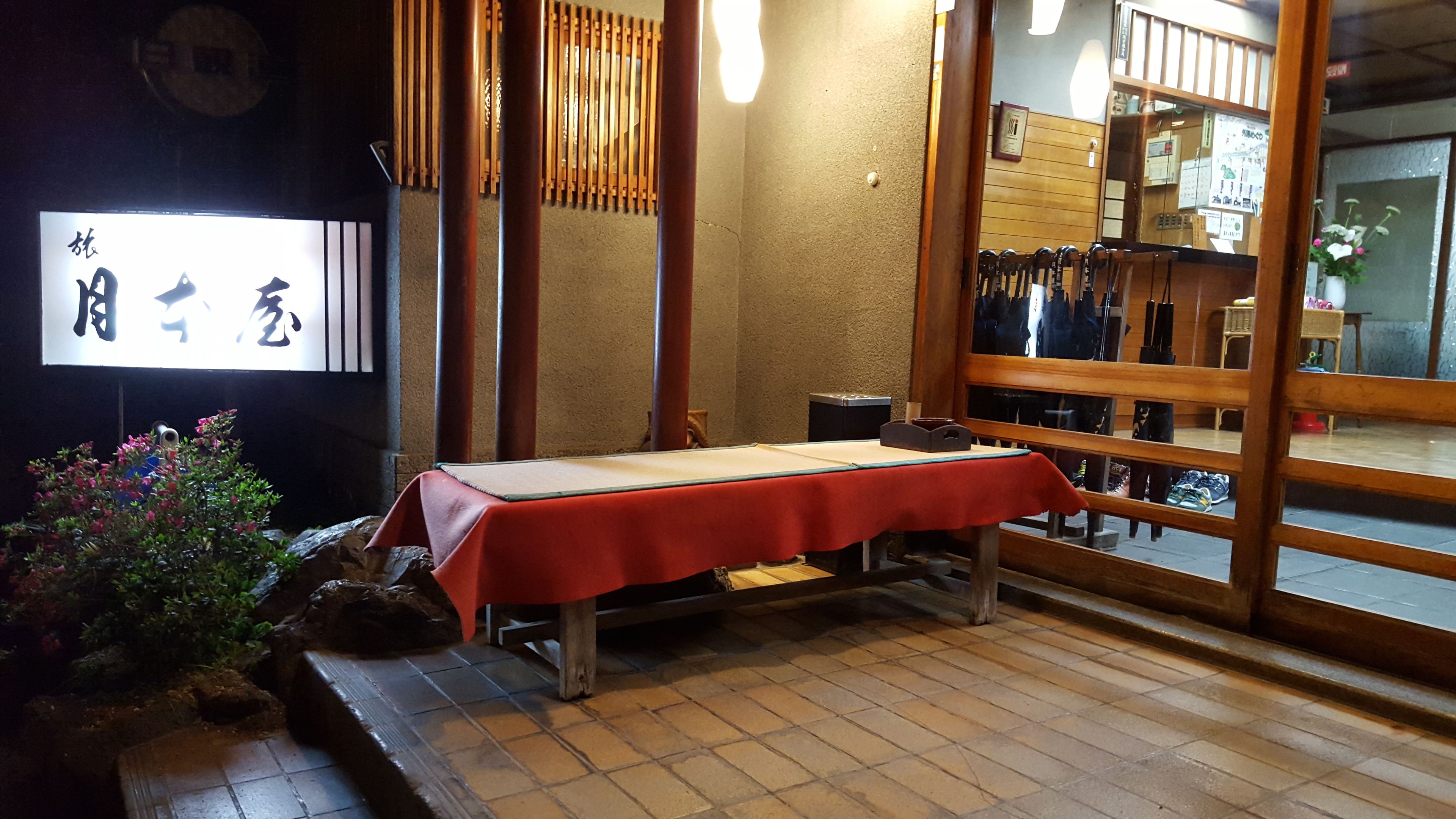 Um quarto japonês tradicional com tatames, uma mesa de madeira baixa e uma porta deslizante.