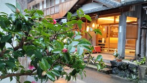 Ein traditionelles japanisches Gebäude mit einer Holzfassade und einem steinbelagten Weg zum Eingang.
