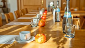 Una mesa con una taza, una manzana y botellas.