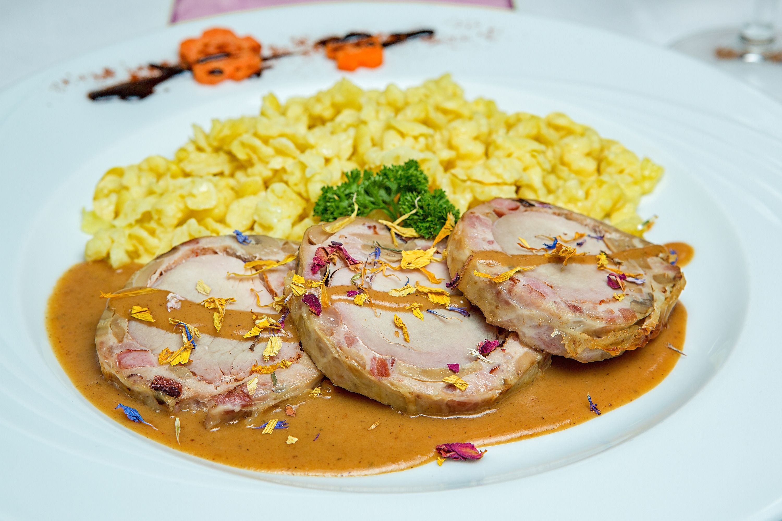 Un plato de comida con carne en rodajas, una guarnición y arroz amarillo.