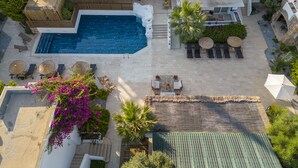An aerial view of a resort with a swimming pool, lounge chairs, and a covered outdoor seating area. - Costa Sariyaz Hotel (Bodrum)