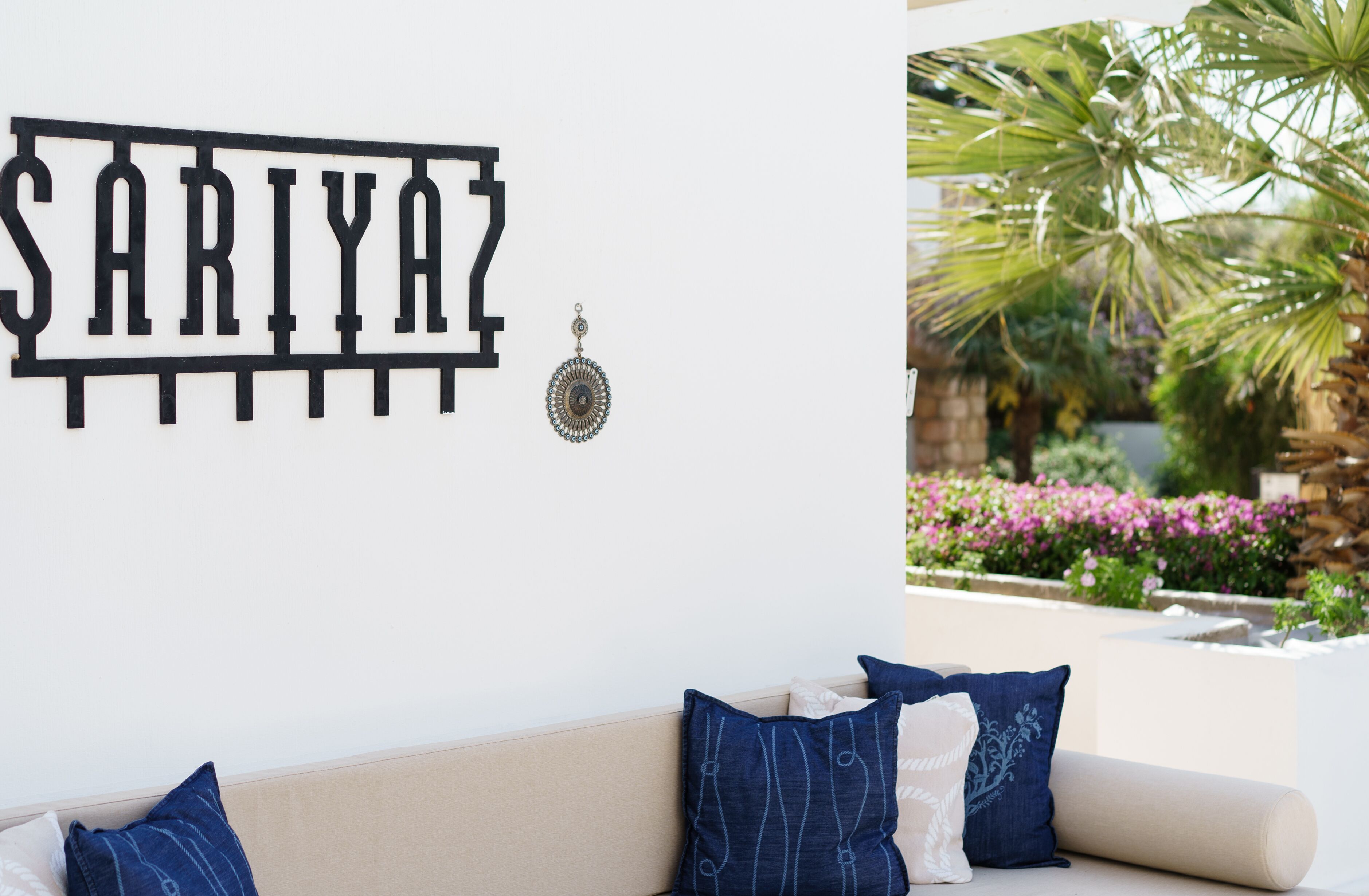 A wall-mounted sign with the name "SARIYAZ" and a decorative earring.