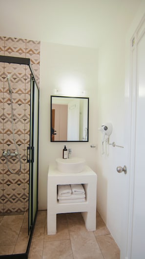 A bathroom with a shower, a sink, a mirror, and a hairdryer. - Costa Sariyaz Hotel (Bodrum)