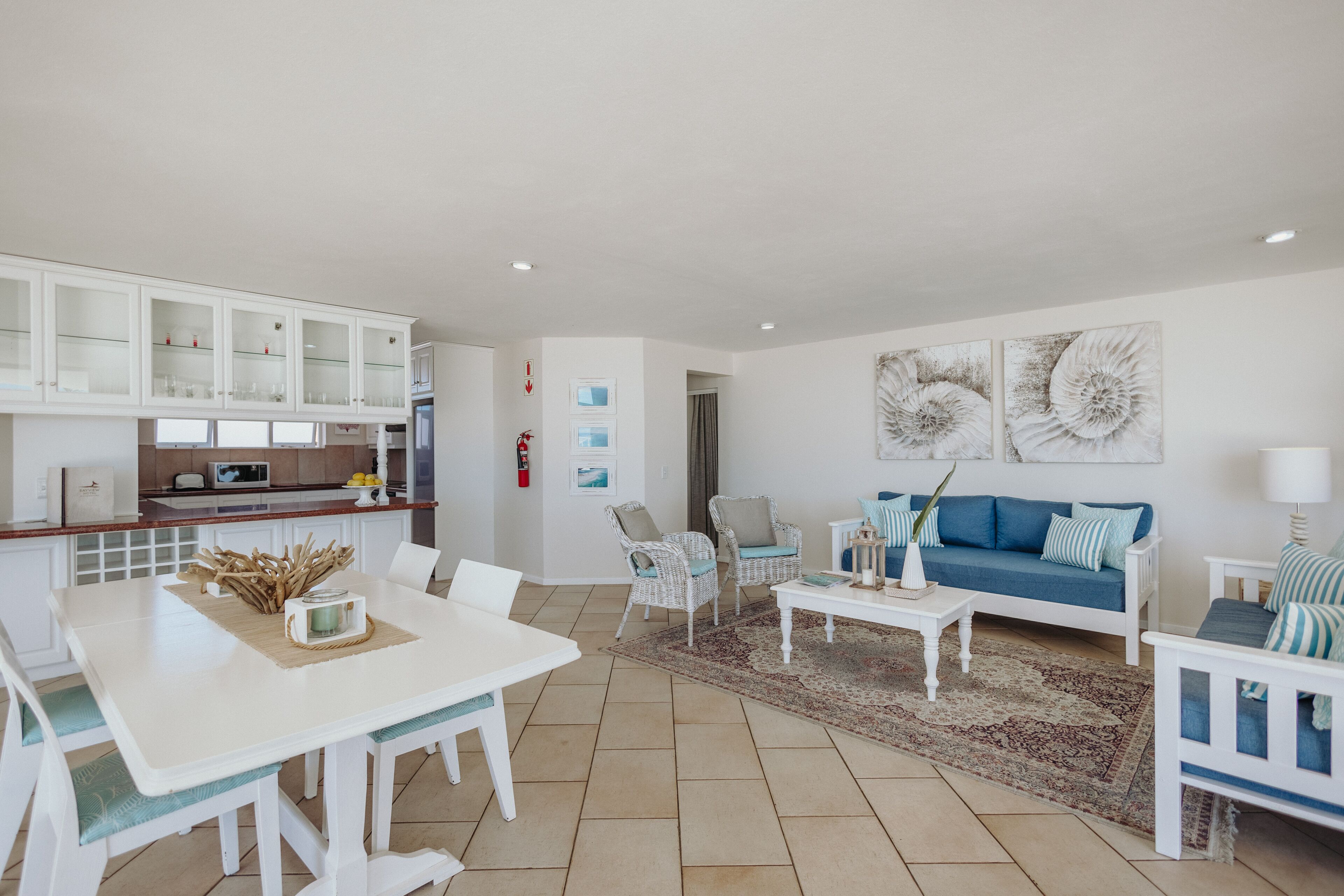 Amplia sala de estar con una mesa de comedor, sofás y una cocina al fondo.