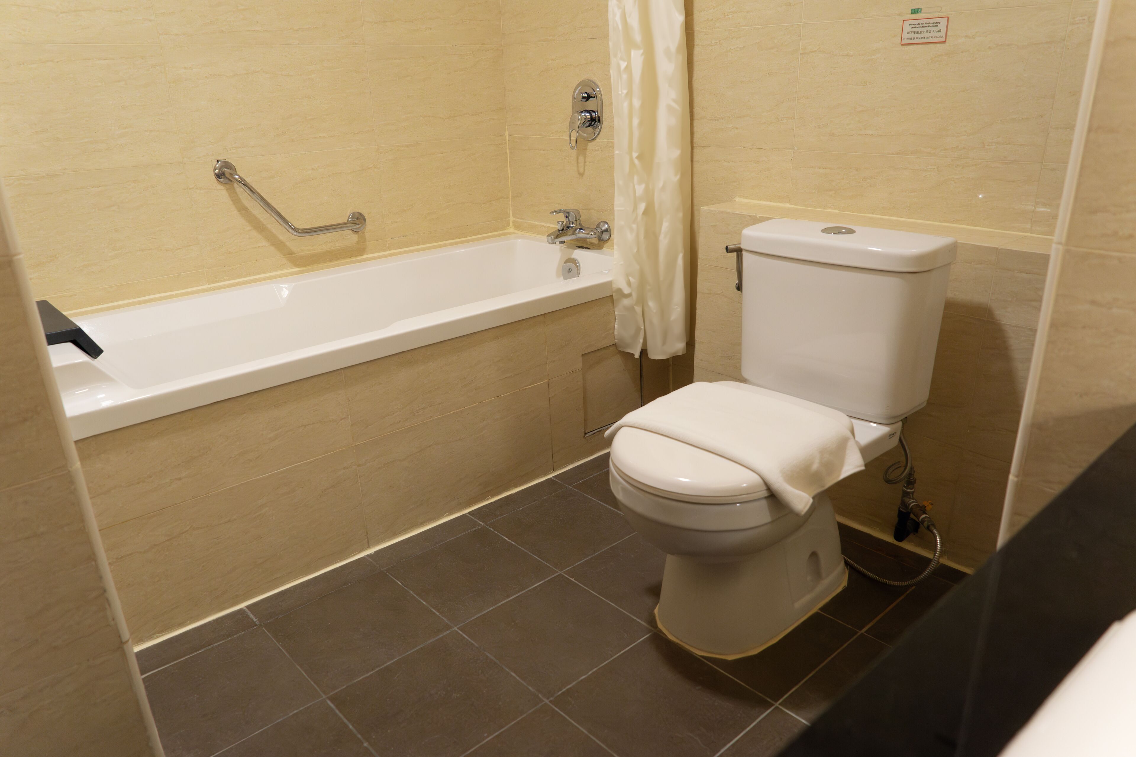 A bathroom with a bathtub, toilet, and shower curtain.