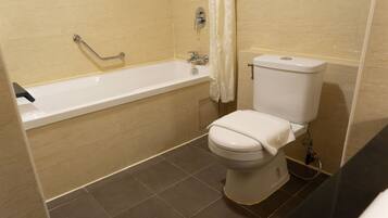 A bathroom with a bathtub, toilet, and shower curtain.