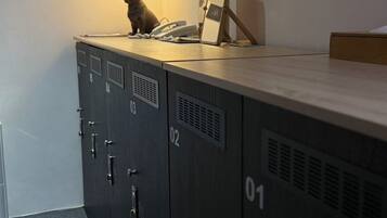 A storage locker with a lamp, a phone, and a picture frame on top.