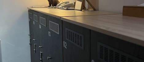 A storage locker with a lamp, a phone, and a picture frame on top.